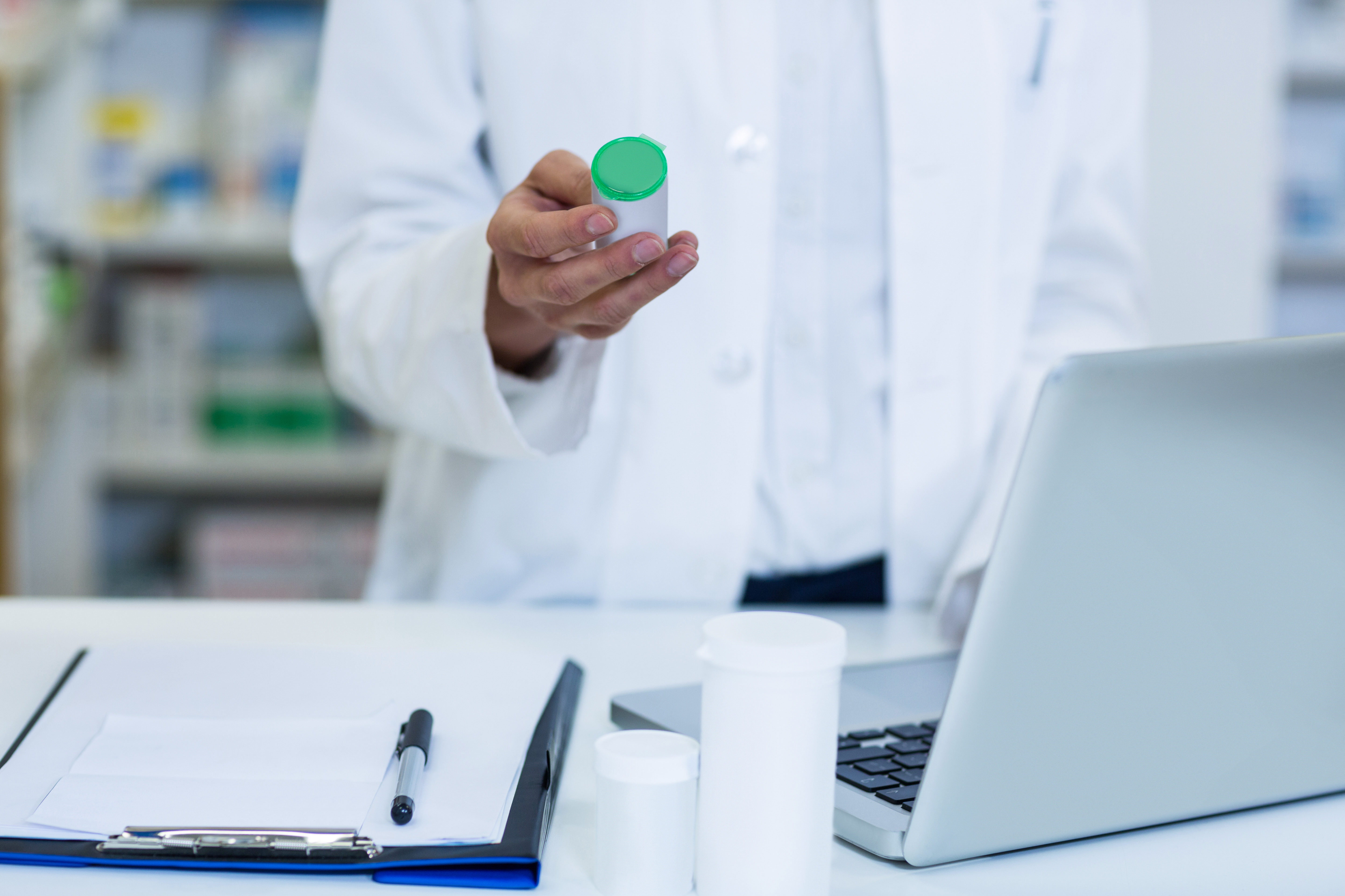 smiling-pharmacist-standing-counter-pharmacy